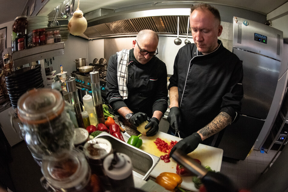 Die Köche Peter Goldmann (r) und Vincenzo Luigi Luggeri kochen in der Corona-Viruskrise unentgeltlich für Helfer und Bedürftige.