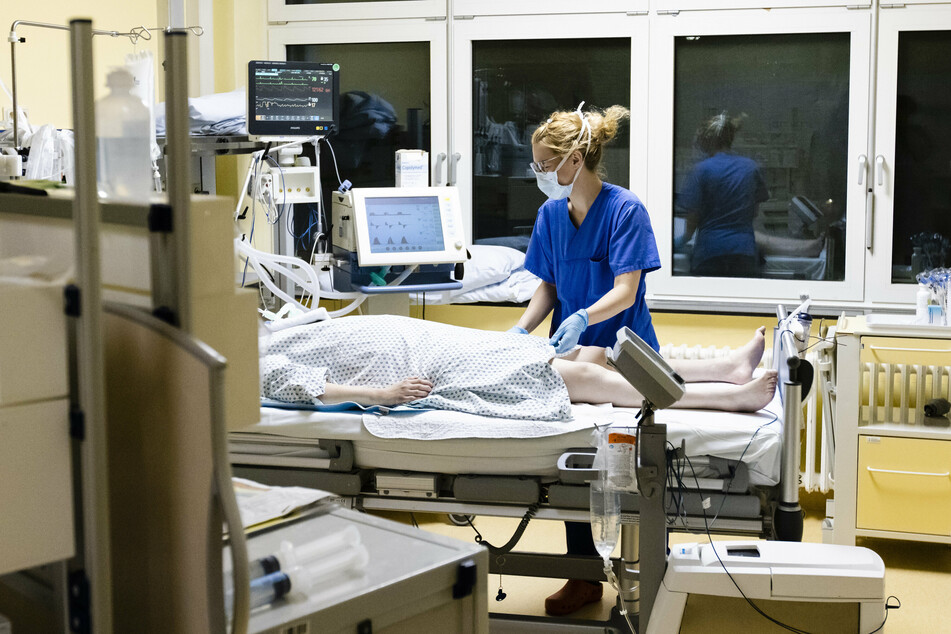 Eine Krankenschwester im Universitätsklinikum Schleswig-Holstein steht am Bett einer Corona-Patientin.