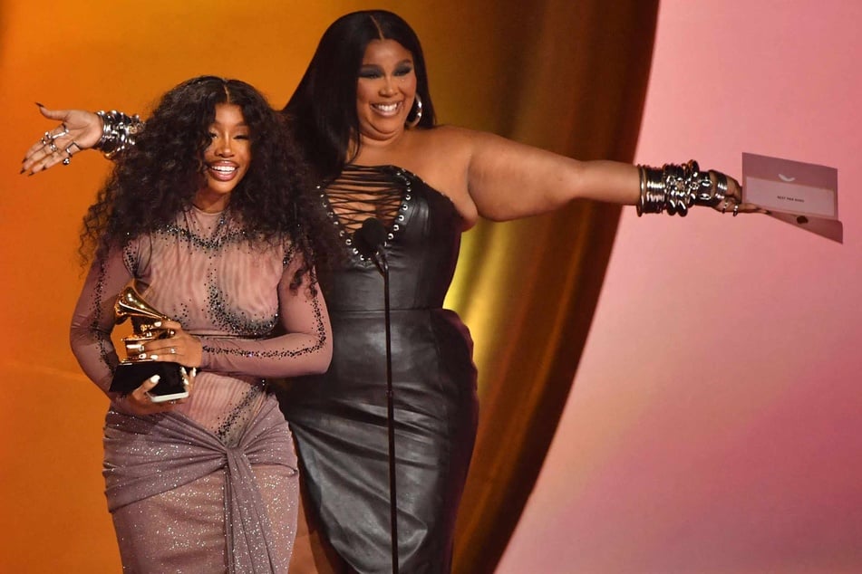 SZA (l.) accepts the Best R&amp;B Song award for Snooze from Lizzo (r.) on stage during the 66th Annual Grammy Awards at the Crypto.com Arena in Los Angeles on February 4, 2024.