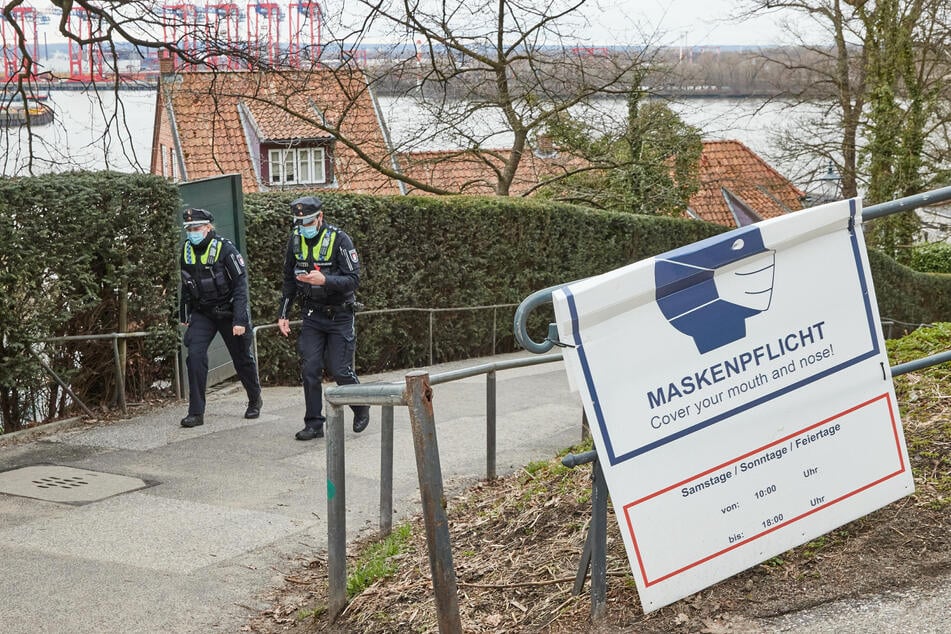 Eine Polizistin und ein Polizist patrollieren am Samstag am Schulberg in Hamburg-Övelgönne und kontrollieren die Einhaltung der geltenden Corona-Regeln.