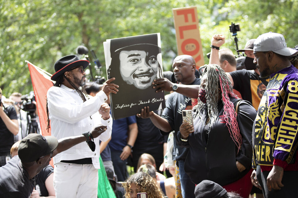 Protesters distribute signs demanding justice for Jacob Blake, who was shot seven times by Kenosha, Wisconsin, police in August 2020.