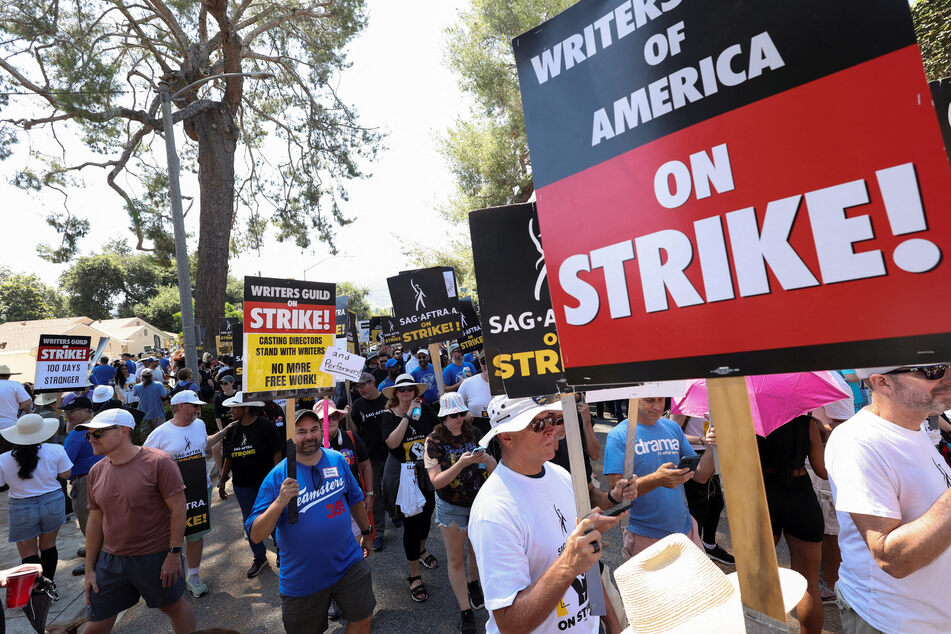 SAG-AFTRA actors and Writers Guild of America (WGA) writers walk the picket line during their ongoing strike outside Walt Disney Studios in Burbank, California.