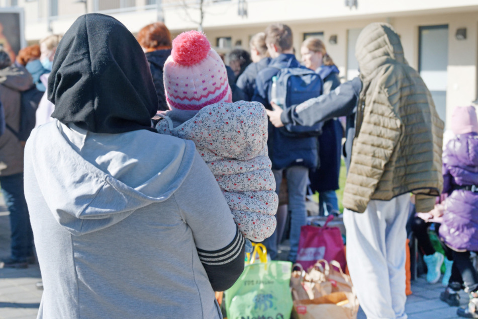 Geflüchtete aus der Ukraine stehen mit ihrem Gepäck vor den Gebäuden eines Flüchtlingsheims. Aufgrund des russischen Angriffkriegs suchen viele Ukrainer Schutz in europäischen Ländern.