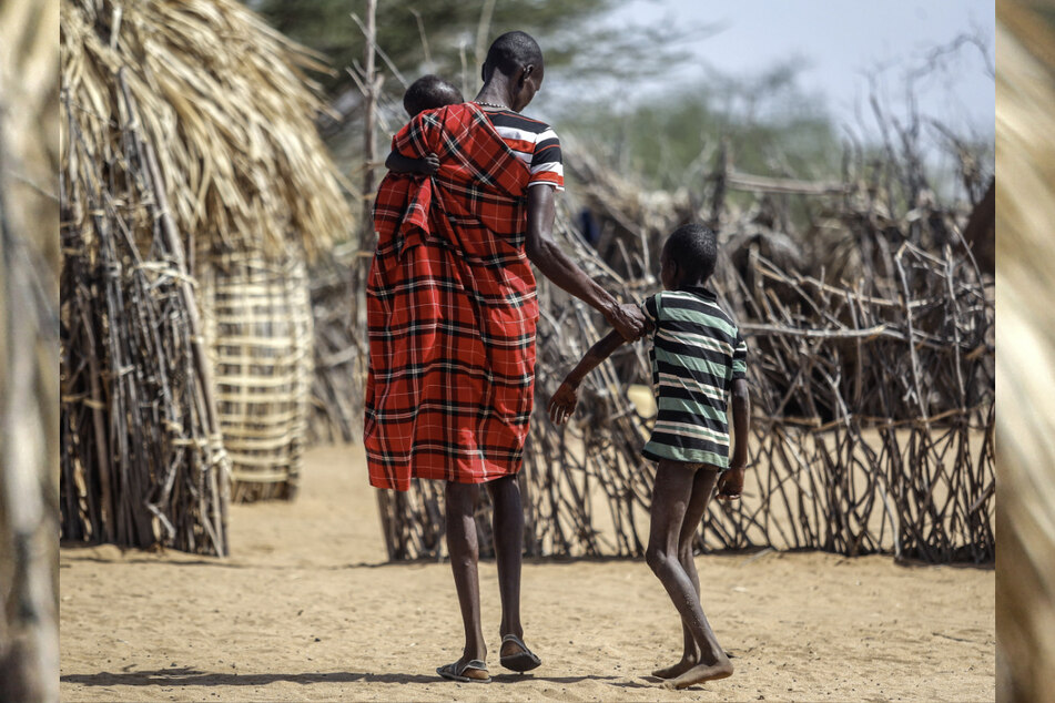 Ein Vater hilft seinem unterernährten Sohn beim Gehen in der Nähe ihrer Hütte im Dorf Lomoputh im Norden Kenias.