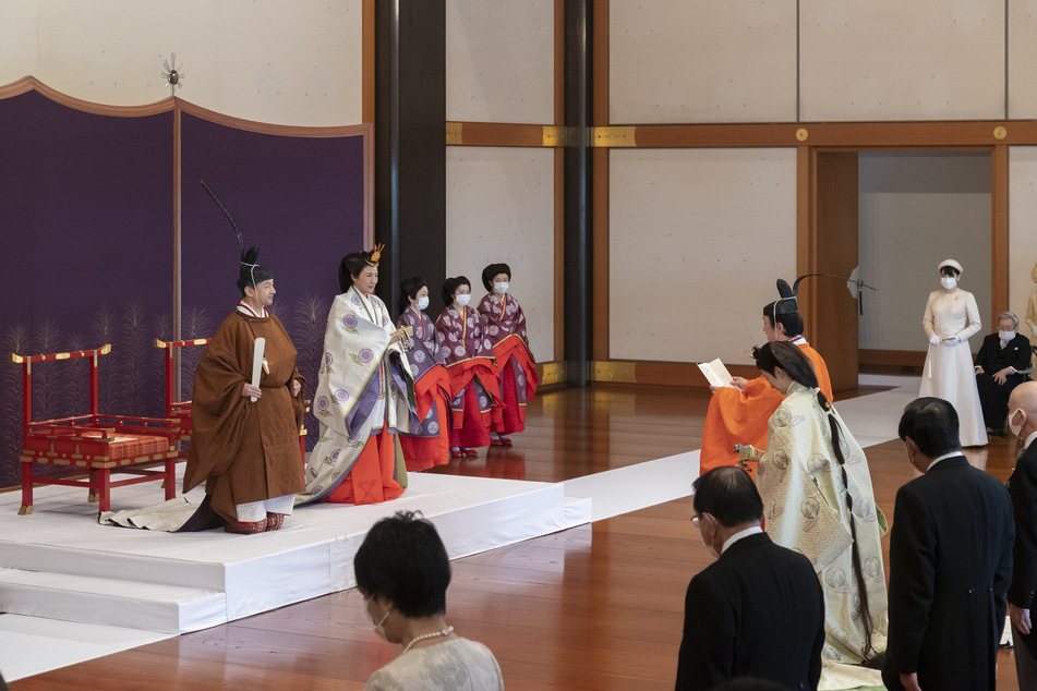 Japans Kronprinz Akishino (M, orangefarbene Kleidung) nimmt zusammen mit seiner Frau Kronprinzessin Kiko an der Zeremonie teil.