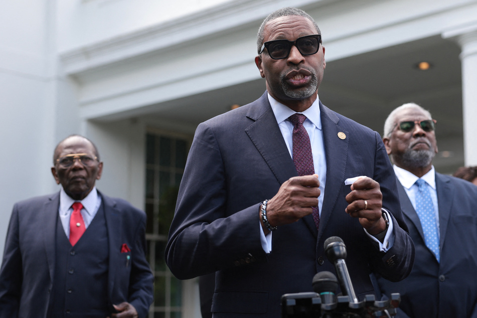 NAACP President Derrick Johnson (c.) and plaintiffs and family members of plaintiffs in the Brown v. Board of Education Supreme Court case John Stokes (l.) and Nathaniel Briggs (r.) speak outside the White House after meeting with President Biden.