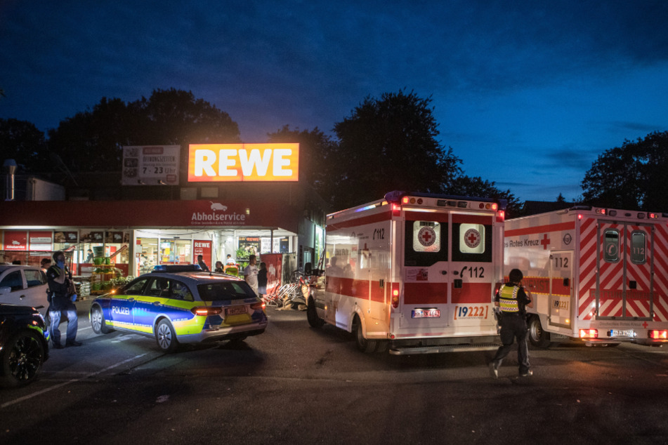 Rettungs- und Peterwagen stehen vor dem Rewe-Markt an der Winsener Straße.