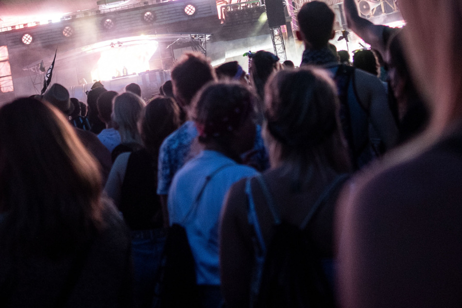 Menschen stehen bei einem Musikfestival vor der Bühne. (Symbolbild)