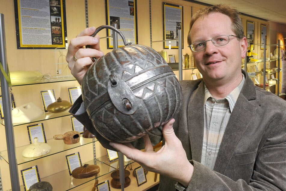 Thomas Uhlmann vom Betten- und Schlafmuseum Freiberg mit einer historischen Wärmflasche.