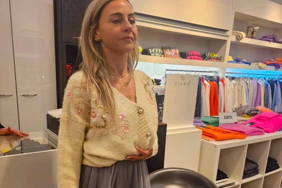 Lucia (37) entscheidet sich schnell für einen auffälligen Cardigan mit blumigen Details.