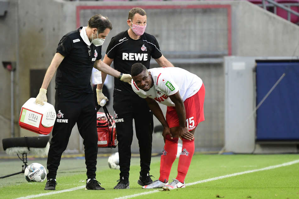 Kölns Jhon Cordoba (r.) steht verletzt am Spielfeldrand.