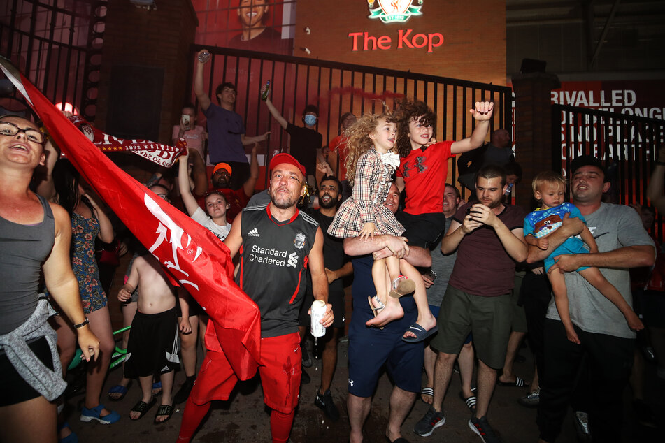 Fans des FC Liverpool feiern vor Anfield, nachdem ihre Mannschaft nach der 1:2-Niederlage von Manchester City gegen Chelsea als Meister der Premier League feststeht.