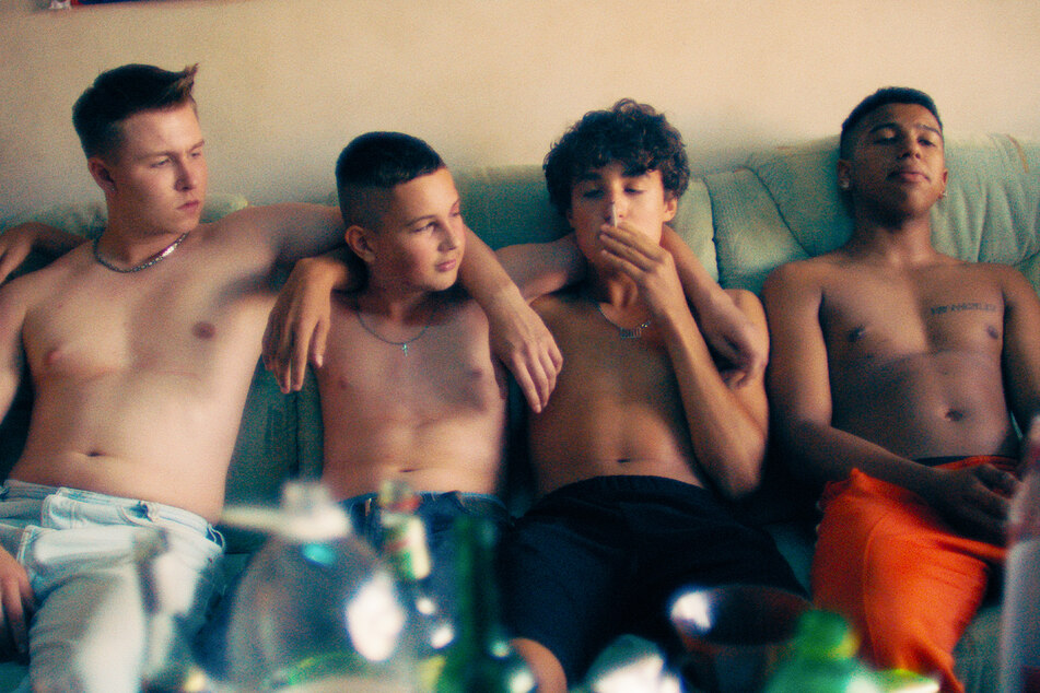 Szene aus dem Film: Julius (Vincent Wiemer, 19, v.l.n.r.), Lukas (Levy Rico Arcos, 17), Gino (Rafael Luis Klein-Heßling, 17) und Sanchez (Aaron Maldonado Morales, 19) kiffen auf einer Couch.