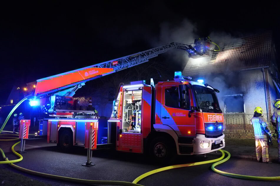 Feuerwehrleute sind im Einsatz bei einem Brand in einem Einfamilienhaus.