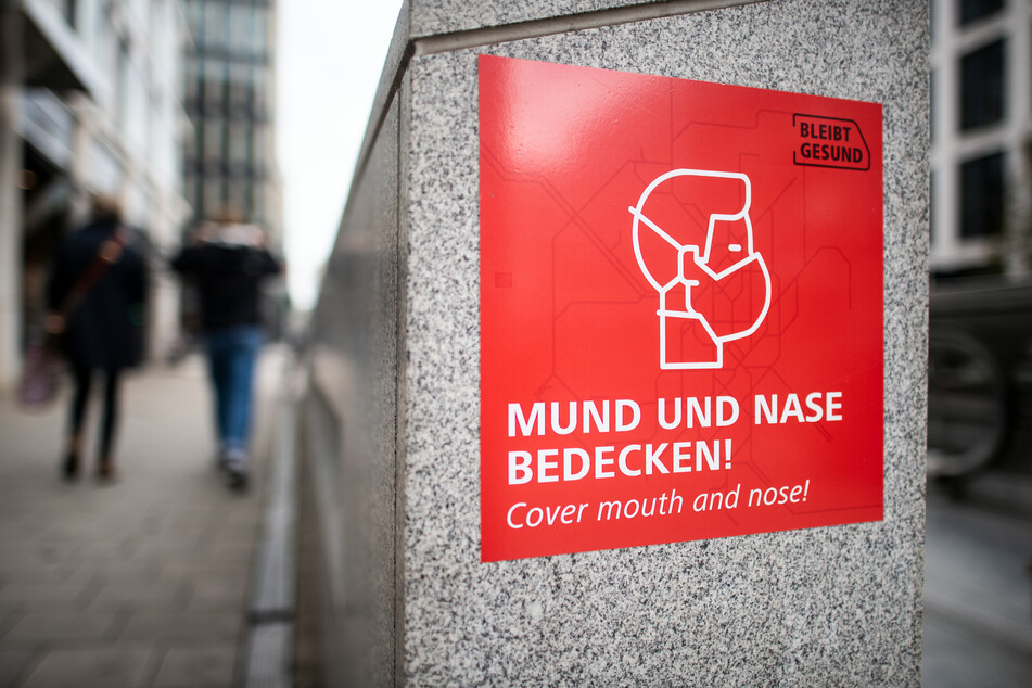 Düsseldorf: Ein Schild mit einem Piktogramm und dem Aufdruck "Mund und Nase bedecken" weist auf das Tragen von Schutzmasken hin.