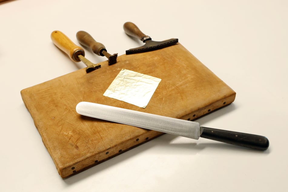 Werkzeuge und Material zum Herstellen von Goldschrift-Titeln auf Buchrücken: Blattgold, Fileten, Vergoldemesser.