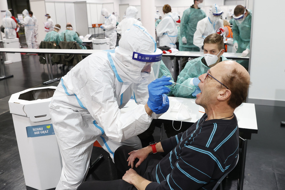 Menschen werden bei Corona-Massentests in der Messehalle in Graz auf das Virus getestet.