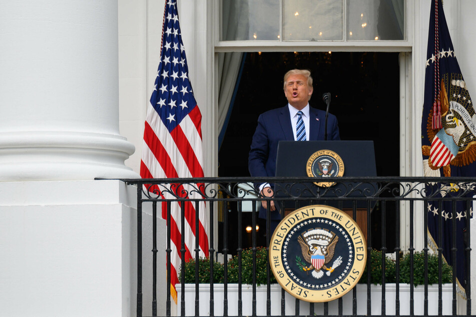 President Donald Trump greeting supporters from the balcony of the White House on October 10.