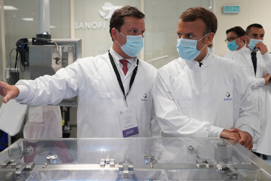 Emmanuel Macron (r.) hört bei einem Besuch einer Fabrik des Pharmaherstellers Sanofi Pasteur Forschern zu.