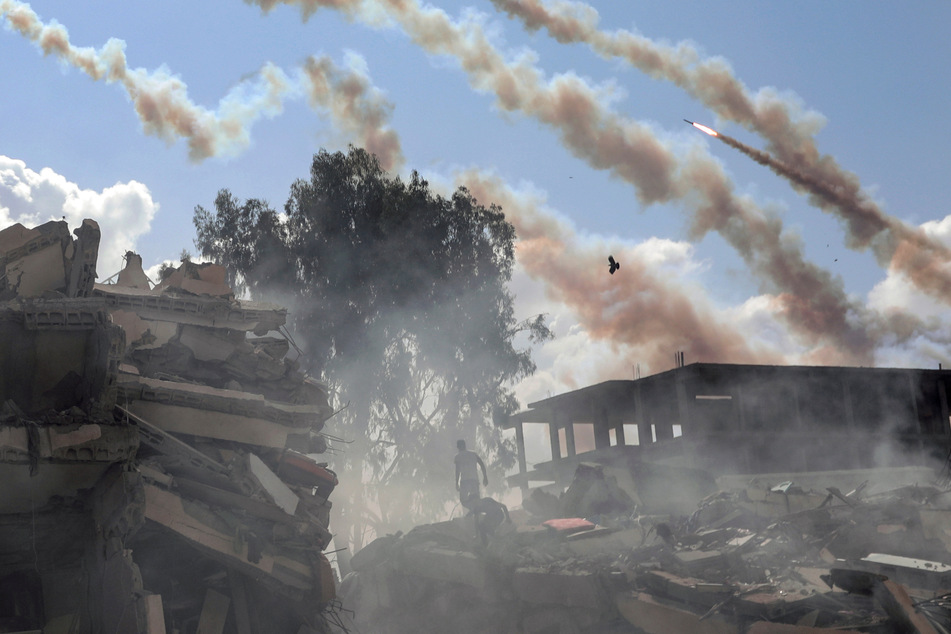 Raketen aus dem Gazastreifen werden über zerstörte Gebäude hinweg auf Israel abgefeuert. (Archivbild)
