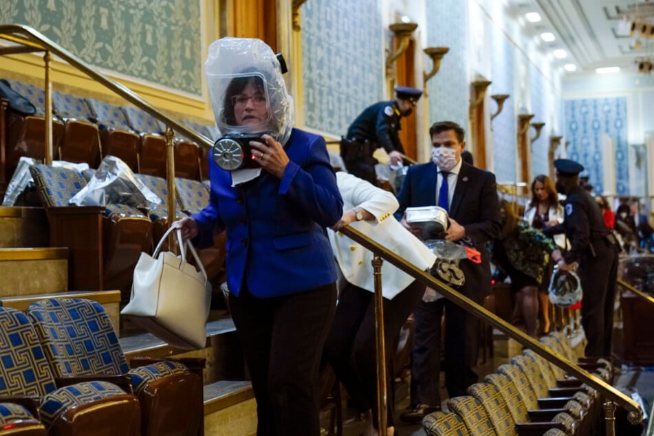 Menschen suchen Schutz auf der Tribüne des Repräsentantenhauses, während Demonstranten versuchen, in die Repräsentantenkammer im US-Kapitol einzudringen.