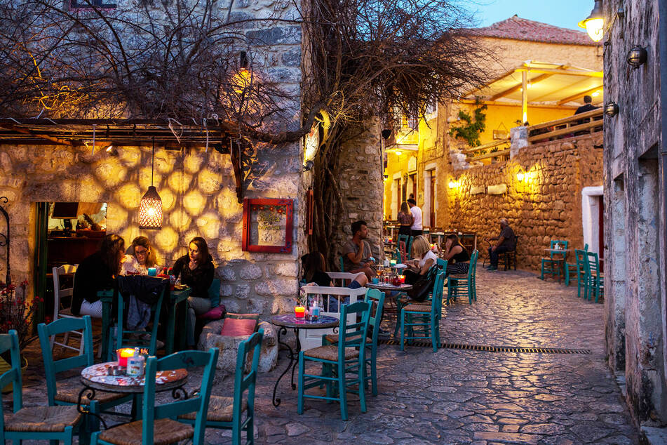 Touristen sitzen in einem Café in Areopoli. Stehen dürfen sie fortan nicht mehr in den Lokalen.
