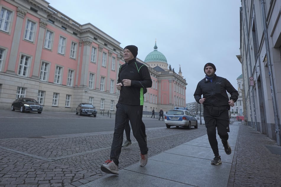 Bundeskanzler Olaf Scholz joggt in Begleitung von seinem Personenschutz am frühen Morgen.