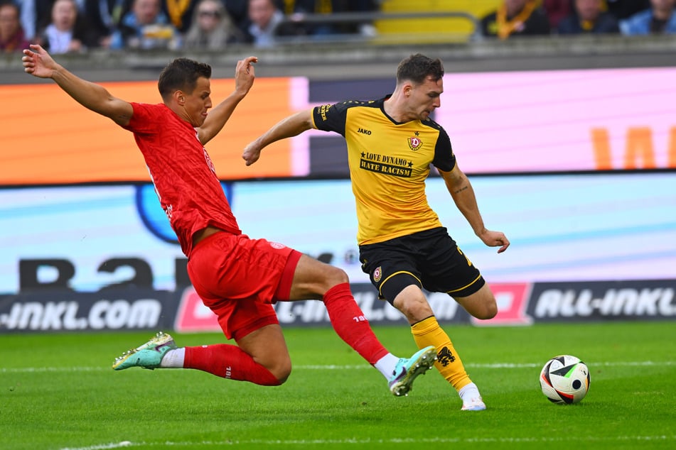 RWE-Akteur Michael Schultz (l.) setzt gegen Dynamos Robin Meißner zur Grätsche an.