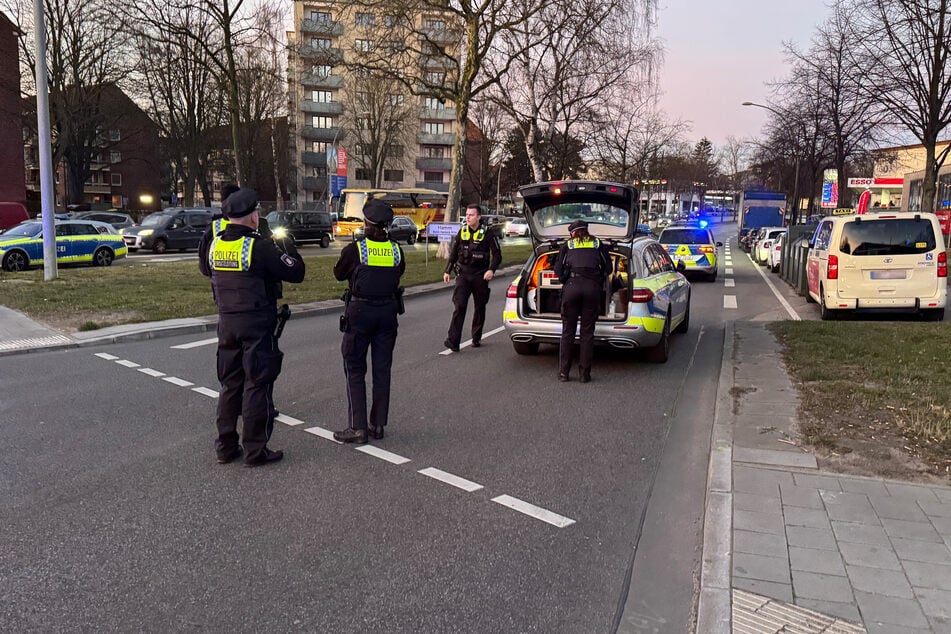 Polizistinnen und Polizisten stehen in der Nähe des Bahnhofs Landwehr.