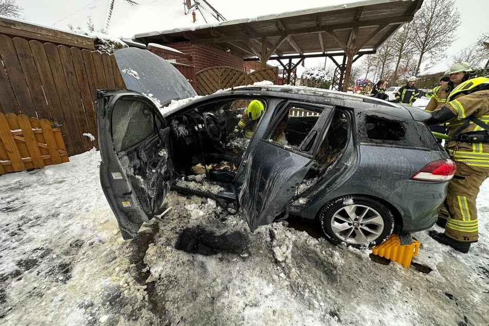 Anwohner löschten das Feuer im Inneren eines Autos mit Schnee und einem Feuerlöscher.