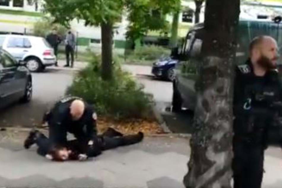 Ein Berliner Polizist schlägt offenbar einem auf den Boden liegenden Mann in den Nacken