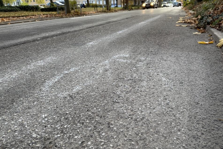 Überbleibsel des Fahrrad-Piktogramms sind auf der Straße zu sehen.