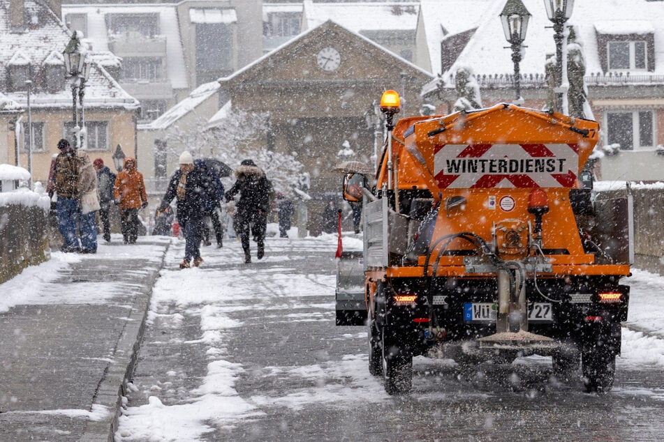 Ein Räumfahrzeug befreit die alte Mainbrücke in Würzburg von Schnee und Eis. (Archivbild)