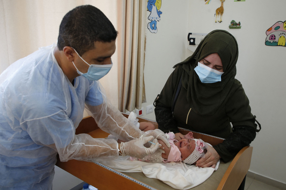 A UNRWA employee provides Polio vaccine and Rota virus vaccines for children in a clinic in Bureij refugee camp central of Gaza Strip on September 9, 2020.