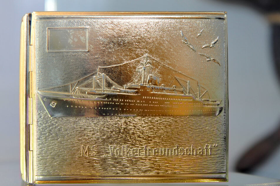 Estuche dorado para cigarrillos con la imagen del MS “Amistad de los Pueblos” (edición de 1973).