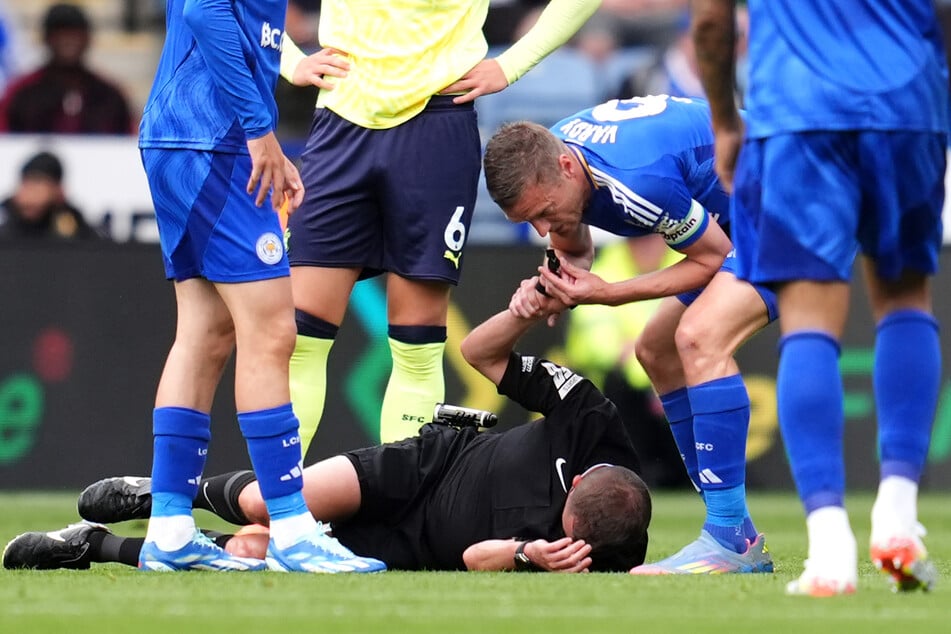 Damit Schiedsrichter David Webb behandelt werden kann, greift Leicester-Stürmer Jamie Vardy (38) kurzerhand selbst zur Pfeife.