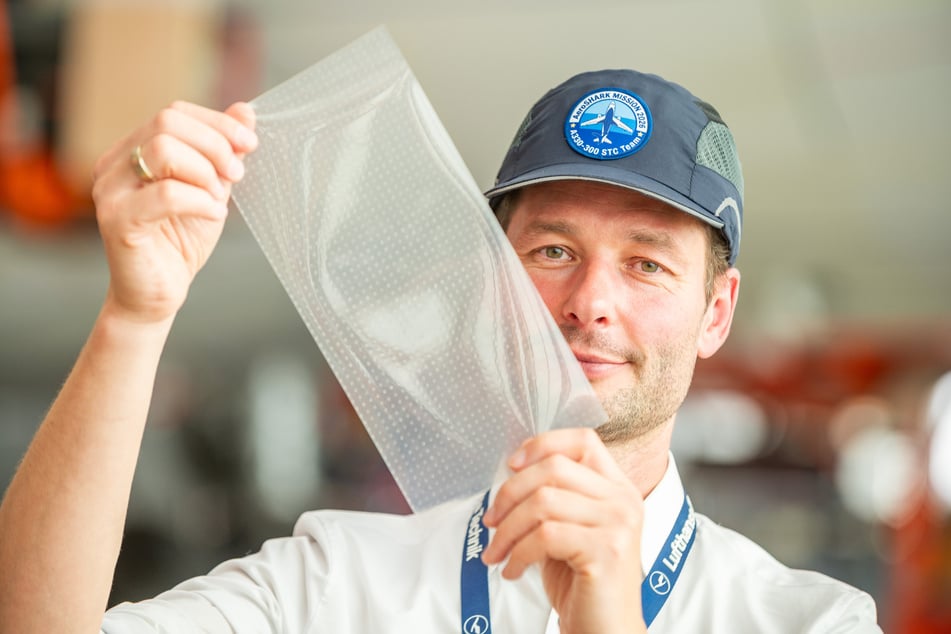 Soenke Burger (40), Leiter Entwicklung von AeroSHARK bei Lufthansa Technik, zeigt ein Teil der Riblet-Folie.