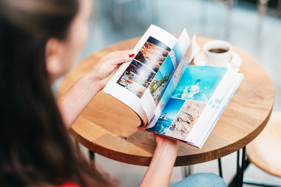 Eine Frau blättert durch ihr Fotobuch.