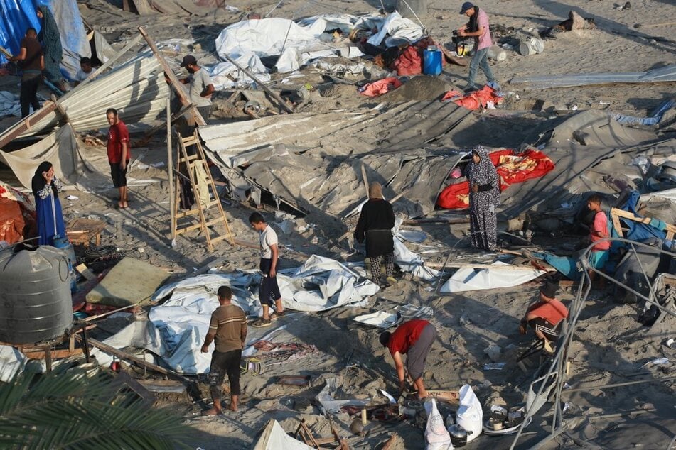 Palestinians inspect the damage at the site of Israeli strikes on a makeshift displacement camp in Mawasi Khan Younis in the Gaza Strip.