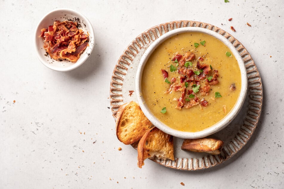 Kartoffelsuppe lässt sich mit vielerlei Zutaten als Topping verfeinern. Neben Würstchen kann man beispielsweise noch Speck und Petersilie auf die Suppe geben.