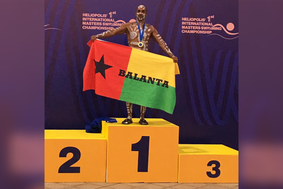 Siphiwe Baleka holds up a Balanta flag after winning six gold medals at the First International Masters Swimming Championships in Cairo, Egypt, in October 2019.