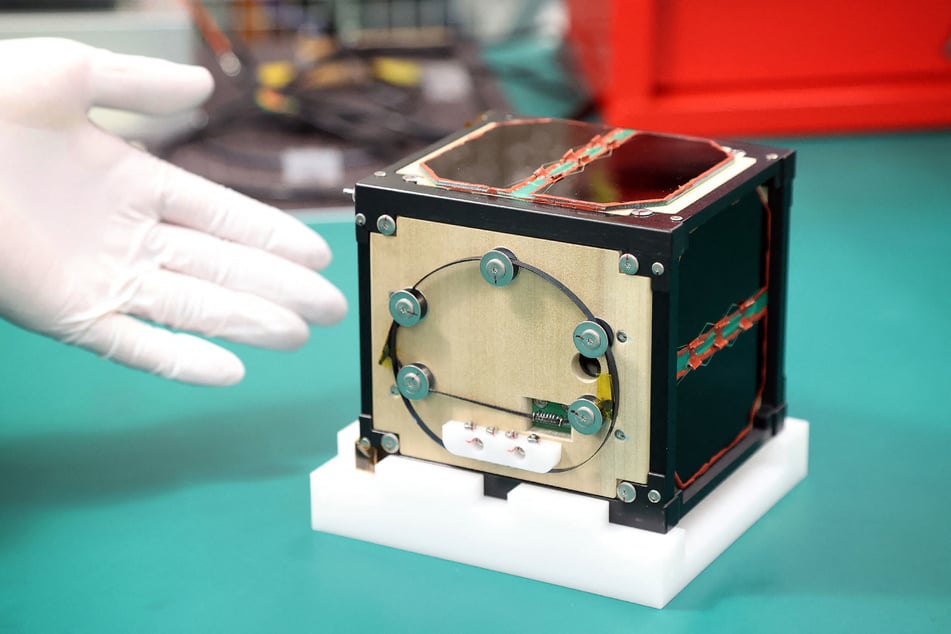 The world's first wooden satellite made from wood and named LignoSat, developed by scientists at Kyoto University and logging company Sumitomo Forestry, is shown during a press conference at Kyoto University in Kyoto on May 28, 2024.