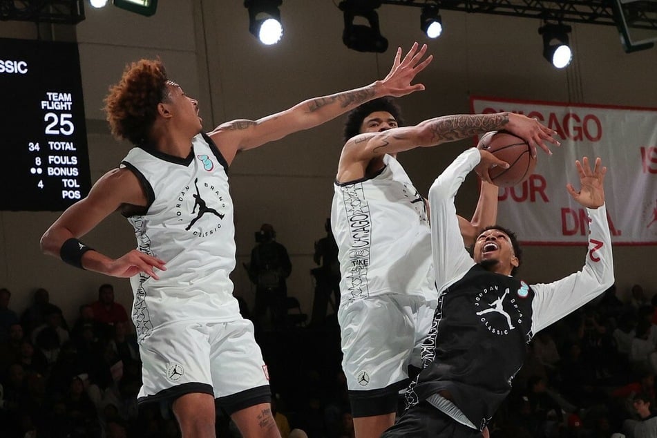 Dior Johnson charging against a double-team defense to score a basket during the men's Jordan Brand Classic.