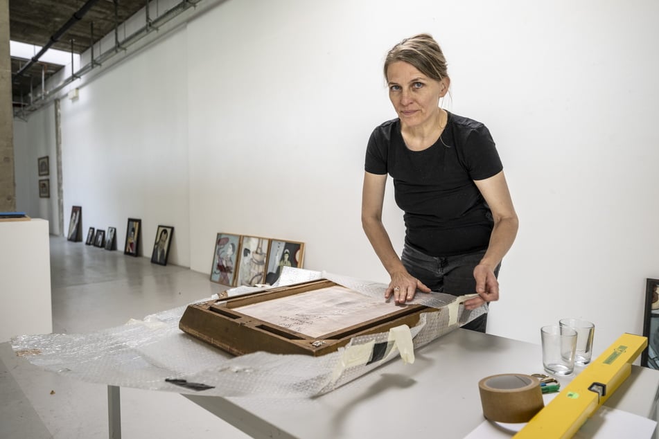 Henriette Schneidewind (45) von der Galerie Borssenanger packt ein Bild von Jan Kummer aus.