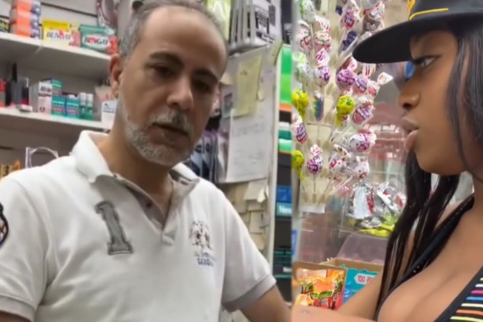 Clerk is not amused by what this model pulls out of her purse