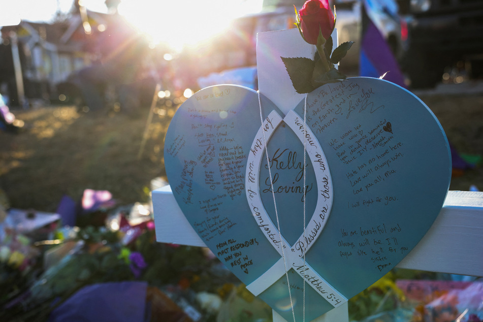 A sign with a rose is displayed on a cross near the Club Q nightclub following a mass shooting in Colorado Springs.