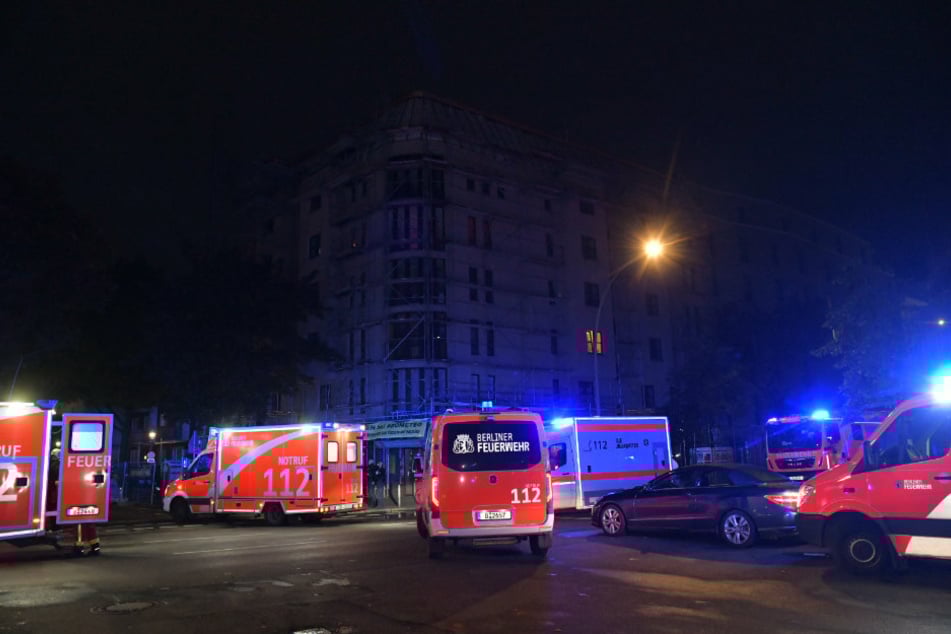 Einsatzkräfte der Feuerwehr stehen in der Steinmetzstraße in Berlin-Schöneberg.