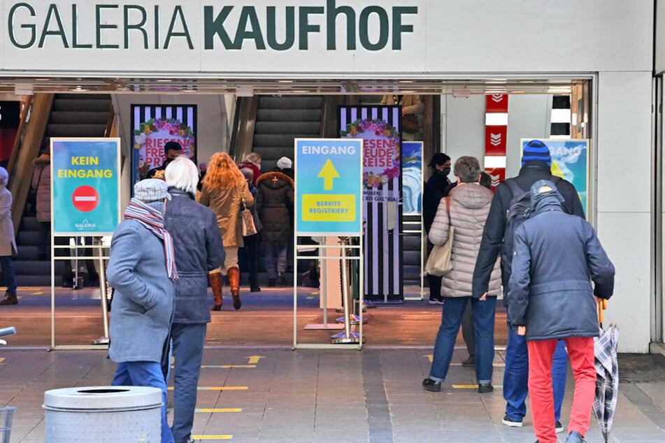Kunden von Galeria Kaufhof warten am Eingang des Kaufhauses in München auf ihren Einlass.