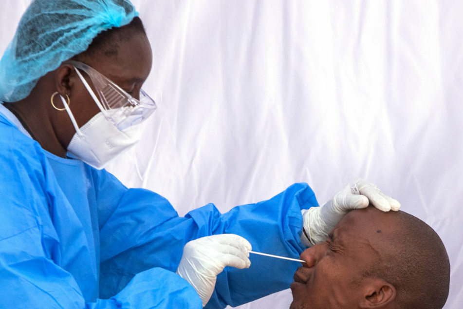 Eine Mitarbeiterin des Gesundheitswesens nimmt im Rahmen einer Testkampagne zur Bekämpfung der Corona-Pandemie einen Nasen-Abstrich von einem Mann.