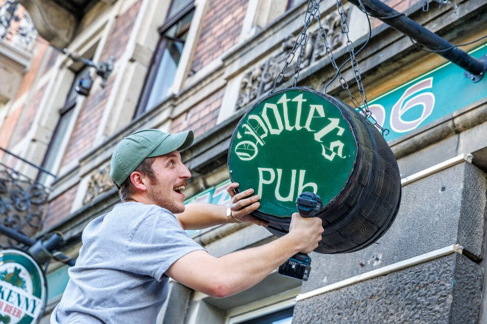 Neu-Wirt Erik Töpfer (26) bringt das "O'Potters"-Fass über dem Eingang seines Pubs an.